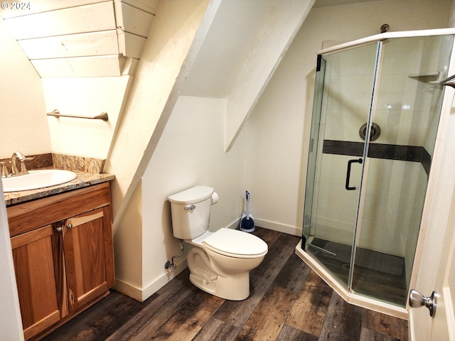 bathroom with a shower with door, vanity, wood-type flooring, and toilet