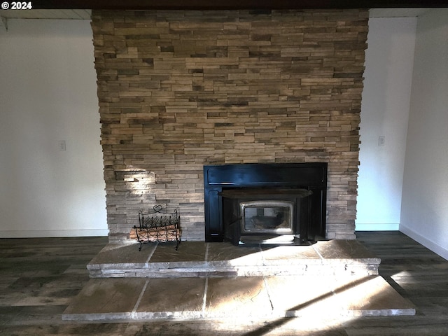 details with hardwood / wood-style flooring and a wood stove