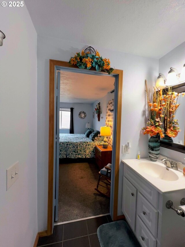 bathroom with tile patterned flooring, vanity, and a textured ceiling