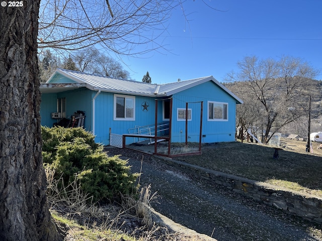 view of front of property with metal roof and crawl space