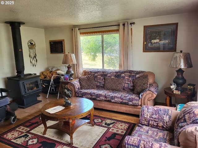 tiled living room featuring a textured ceiling and a wood stove