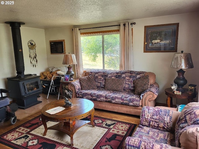 living room featuring tile patterned flooring, a wood stove, and a textured ceiling