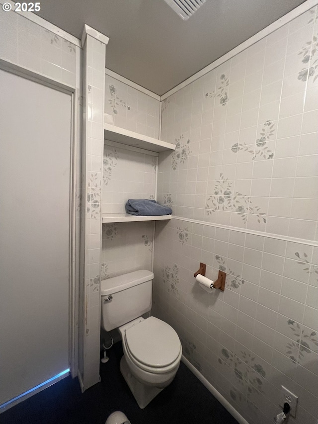 bathroom with toilet and tile walls