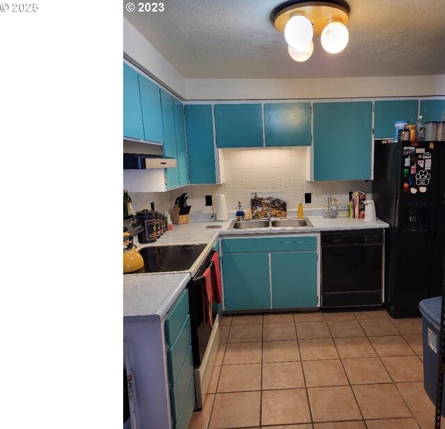 kitchen with sink, a textured ceiling, blue cabinetry, and black appliances