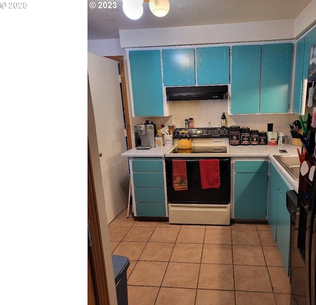 kitchen featuring blue cabinets, light tile patterned floors, electric range, and backsplash