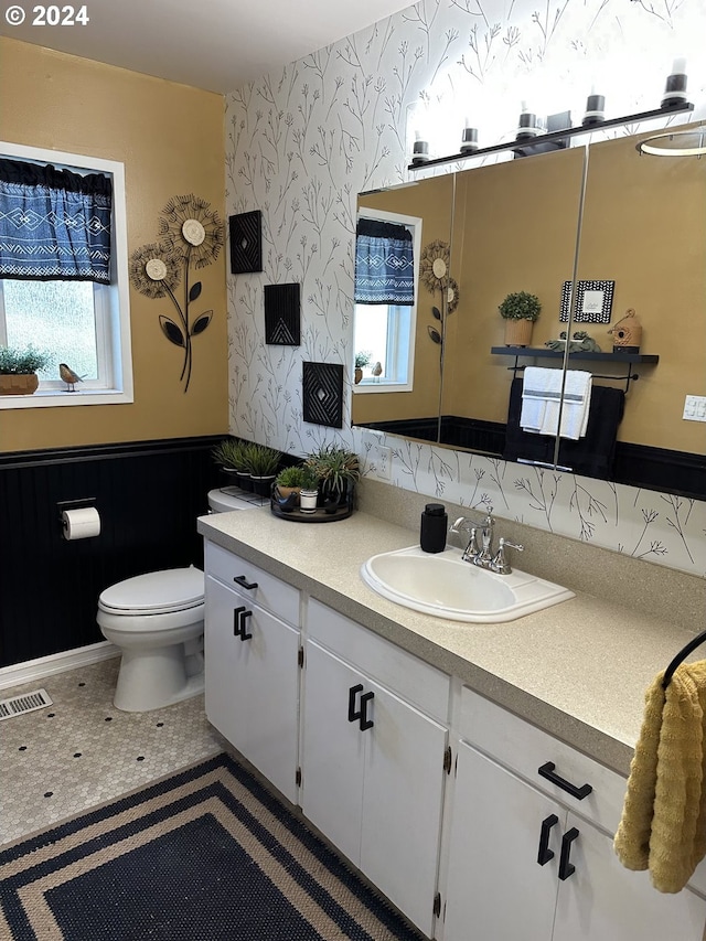 bathroom with tile patterned flooring, vanity, and toilet