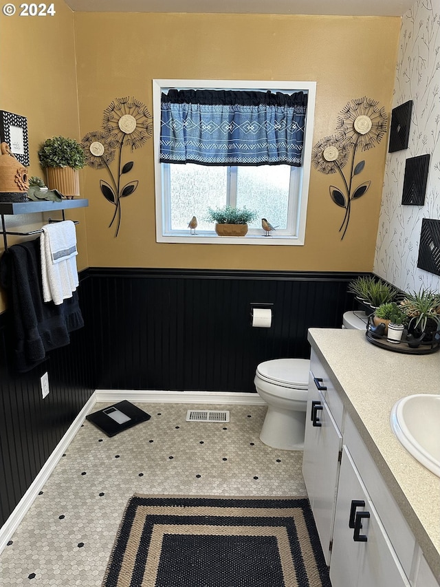 bathroom with tile patterned flooring, vanity, and toilet