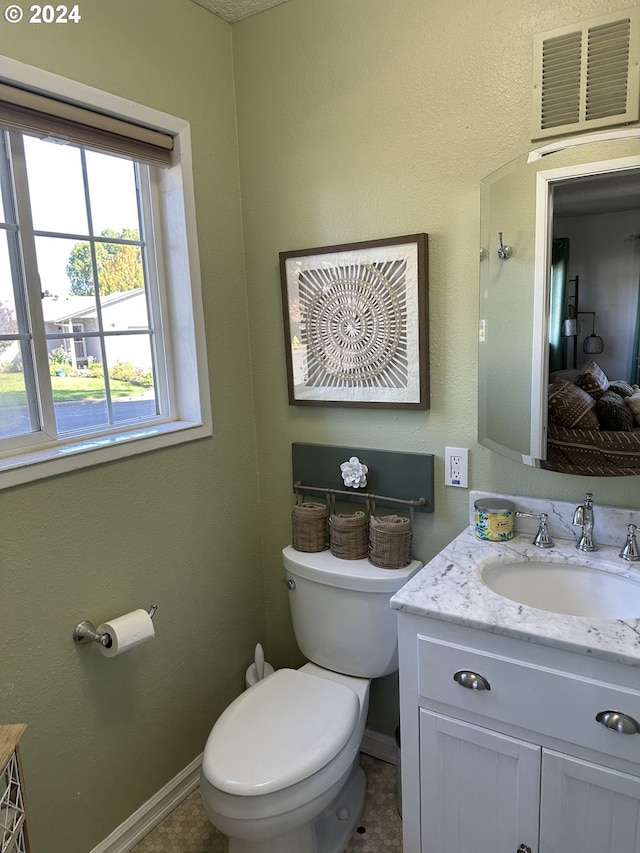 bathroom with tile patterned flooring, vanity, and toilet