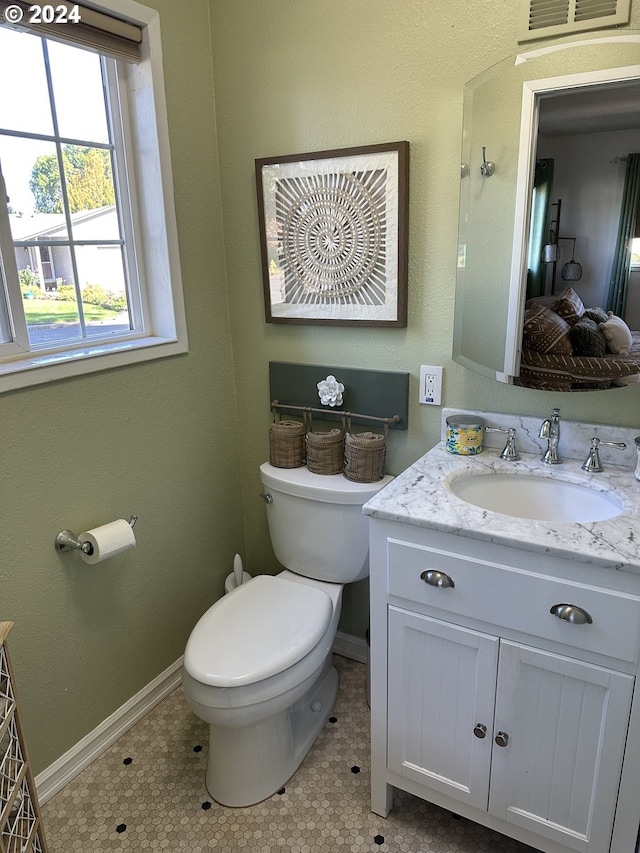 bathroom featuring tile patterned flooring, vanity, and toilet