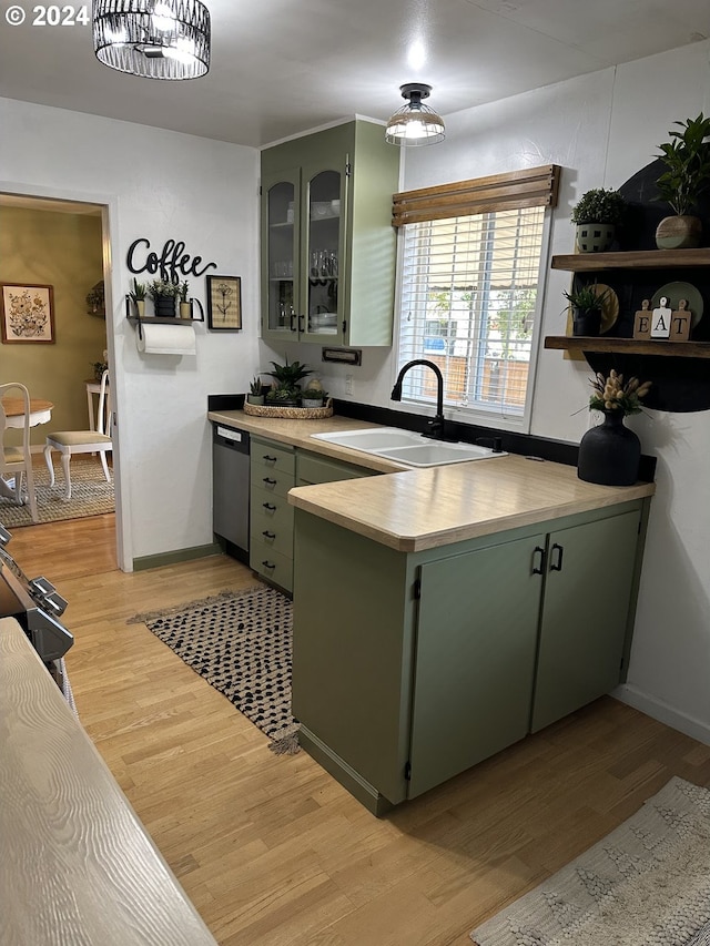 kitchen with green cabinetry, light wood-type flooring, and sink