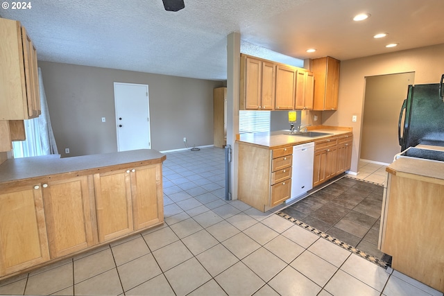 kitchen featuring sink, light brown cabinets, black fridge, plenty of natural light, and white dishwasher