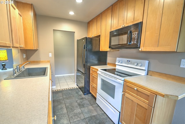 kitchen with dark tile patterned floors, white appliances, and sink