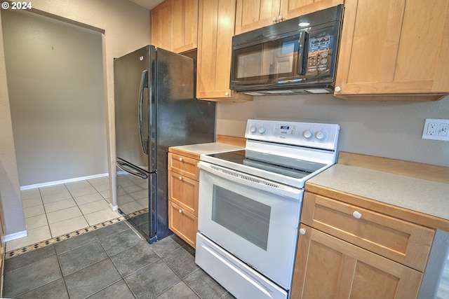 kitchen featuring black appliances and dark tile patterned floors