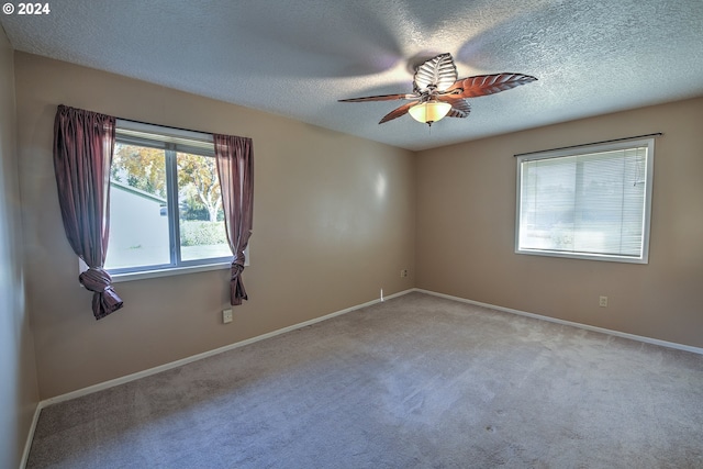 carpeted spare room featuring a textured ceiling and ceiling fan