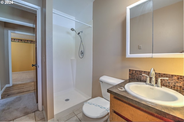 bathroom with vanity, a shower, backsplash, tile patterned floors, and toilet