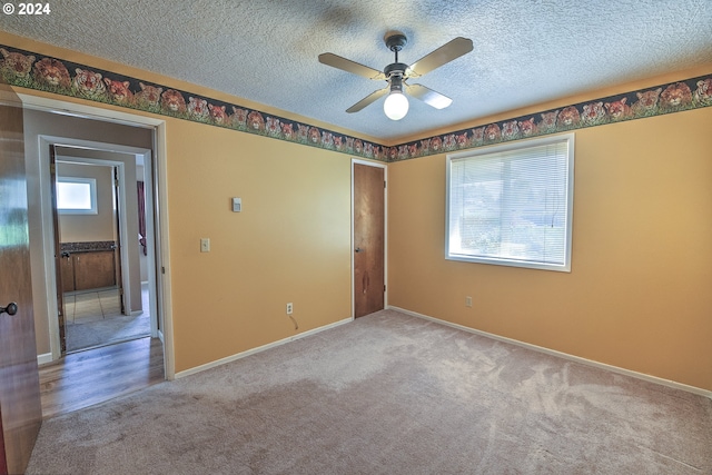 carpeted empty room featuring ceiling fan and a textured ceiling