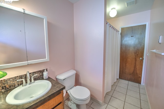 bathroom featuring toilet, vanity, tasteful backsplash, and tile patterned floors