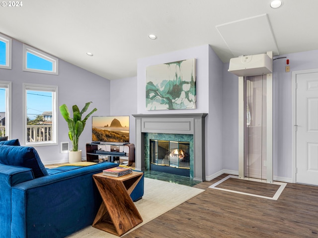 living room with lofted ceiling, a high end fireplace, and hardwood / wood-style floors