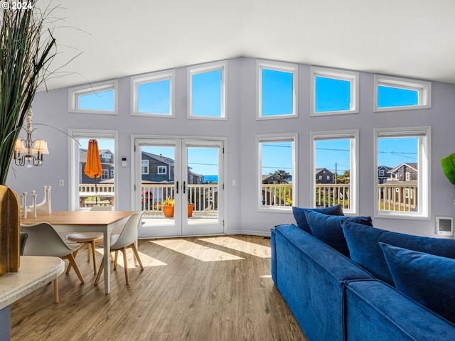 sunroom / solarium featuring french doors, lofted ceiling, and a chandelier