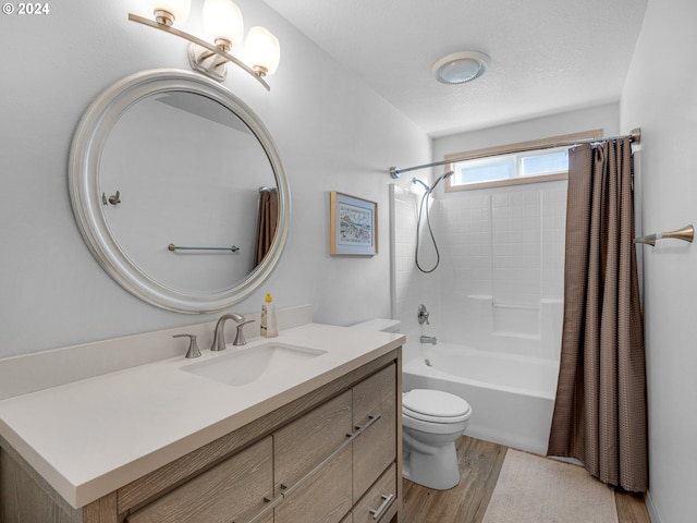 full bathroom featuring vanity, a textured ceiling, hardwood / wood-style flooring, shower / bathtub combination with curtain, and toilet