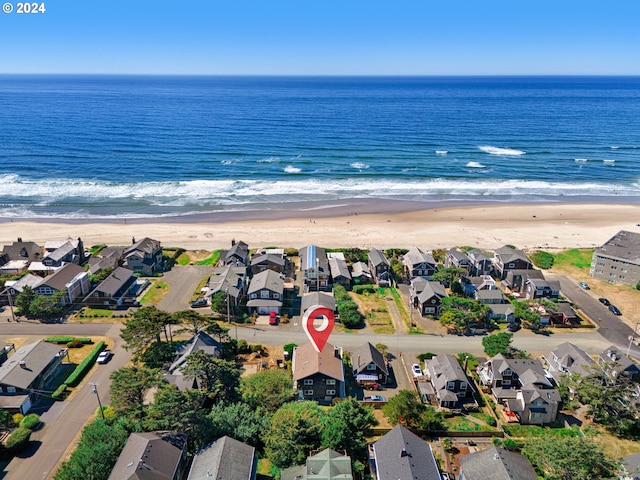 birds eye view of property featuring a water view and a beach view