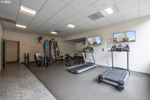 workout room featuring tile patterned floors and a drop ceiling