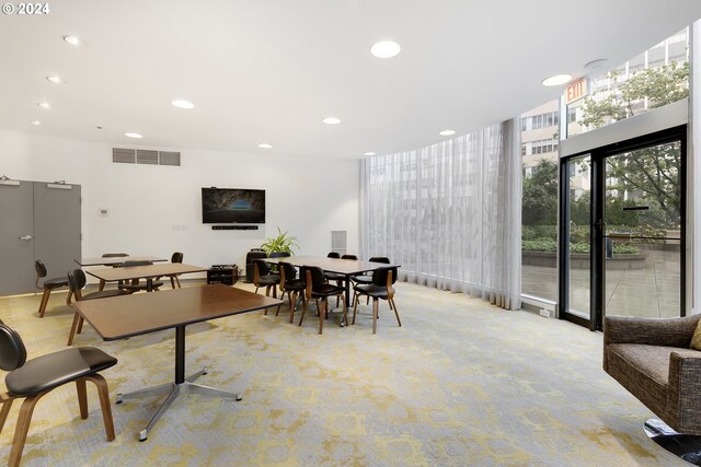 interior space with light carpet and expansive windows