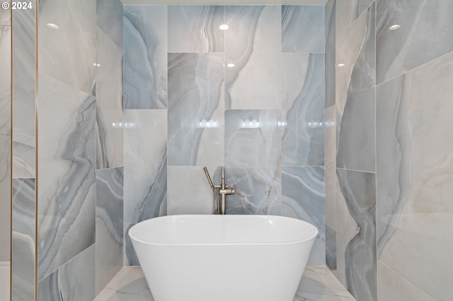 bathroom featuring tile walls and a bathtub