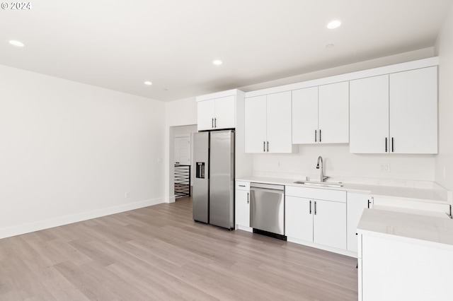 kitchen featuring white cabinets, light hardwood / wood-style floors, appliances with stainless steel finishes, and sink