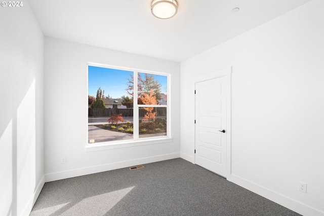 empty room featuring dark colored carpet