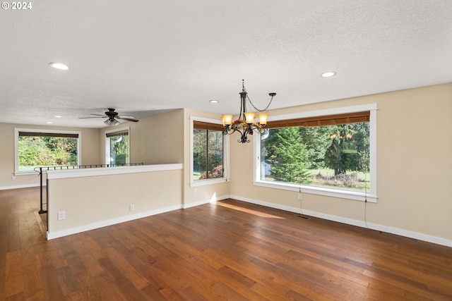 empty room featuring dark hardwood / wood-style floors, a chandelier, and a textured ceiling