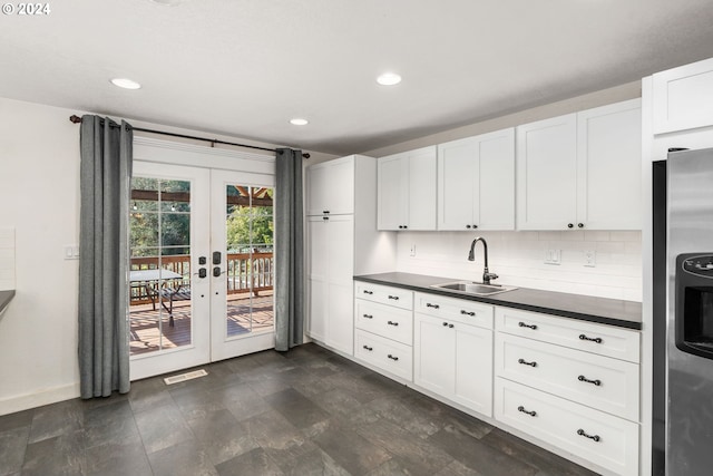 kitchen featuring sink, backsplash, stainless steel refrigerator with ice dispenser, white cabinets, and french doors