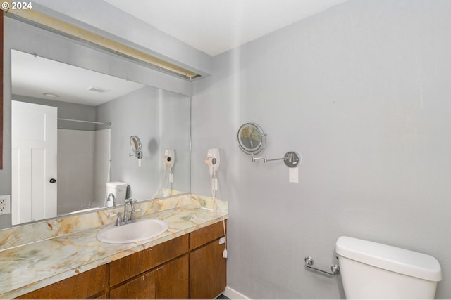 bathroom featuring walk in shower, vanity, and toilet