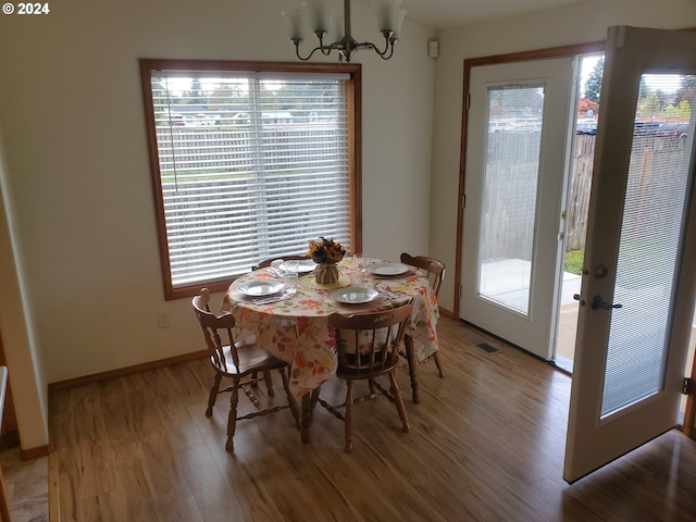 dining space with an inviting chandelier, hardwood / wood-style floors, and a healthy amount of sunlight