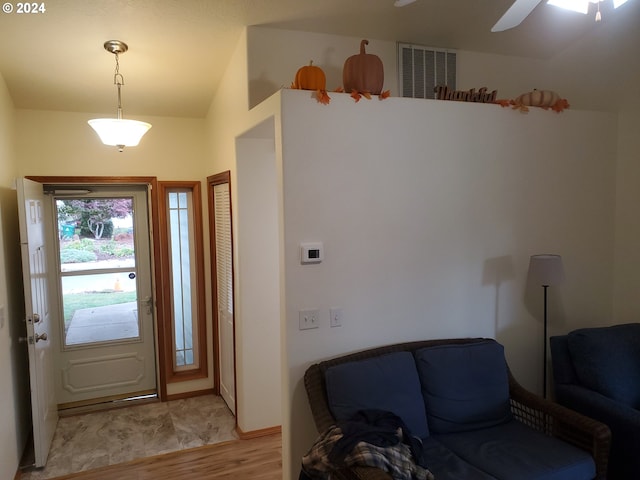 foyer featuring vaulted ceiling, light hardwood / wood-style floors, and ceiling fan