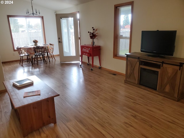 living room with hardwood / wood-style floors, a notable chandelier, and plenty of natural light