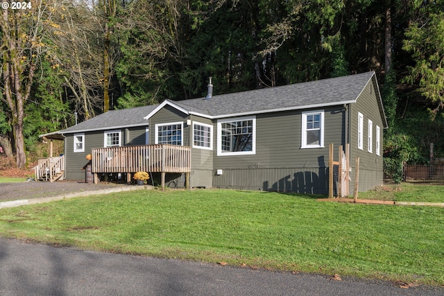 view of front of house featuring a front lawn and a deck