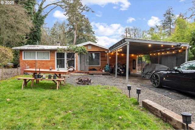 rear view of property featuring a lawn and a carport