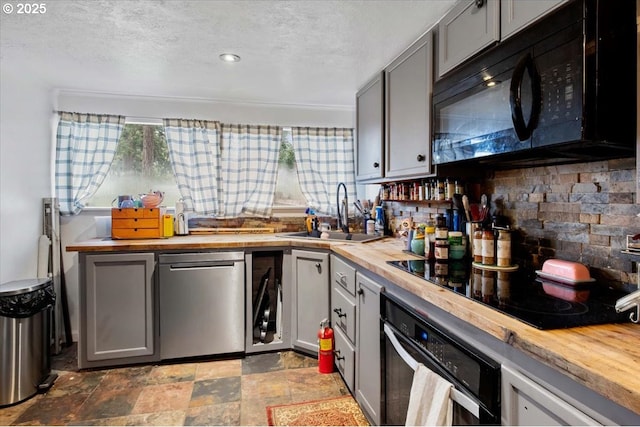 kitchen with wood counters, sink, black appliances, and gray cabinetry