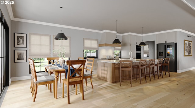 dining room featuring crown molding, sink, a wealth of natural light, and light hardwood / wood-style floors