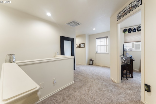 hall featuring light colored carpet