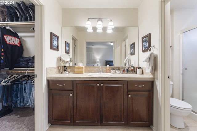 bathroom with toilet, tile floors, and vanity