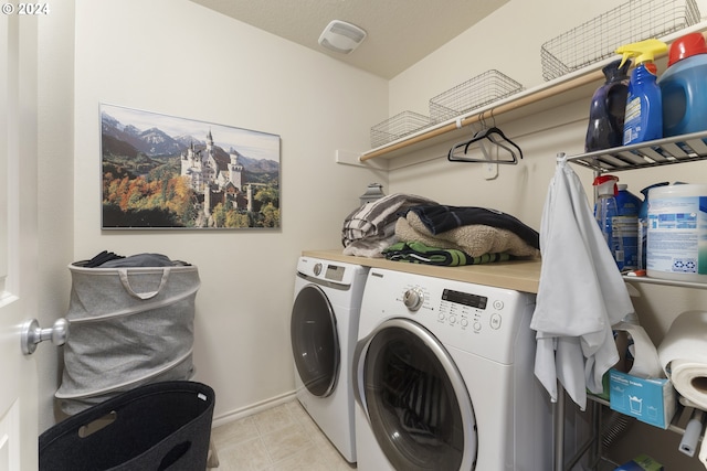 clothes washing area with a mountain view, washing machine and clothes dryer, and light tile floors