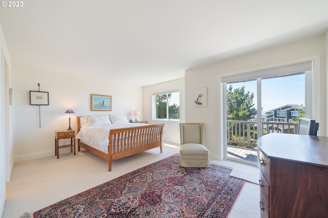 bedroom featuring light carpet and access to outside