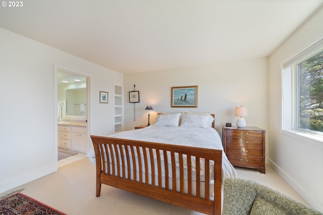 carpeted bedroom with ensuite bath and multiple windows