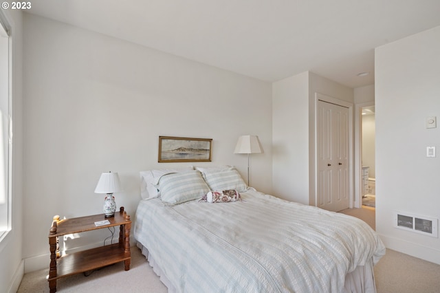 bedroom featuring light colored carpet and a closet