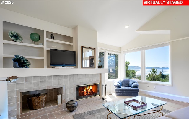 living room featuring a fireplace, built in features, plenty of natural light, and lofted ceiling