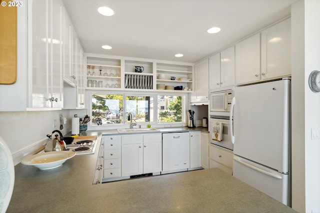 kitchen featuring sink, white cabinets, and white appliances