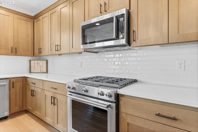 kitchen with stainless steel appliances, light hardwood / wood-style floors, and backsplash