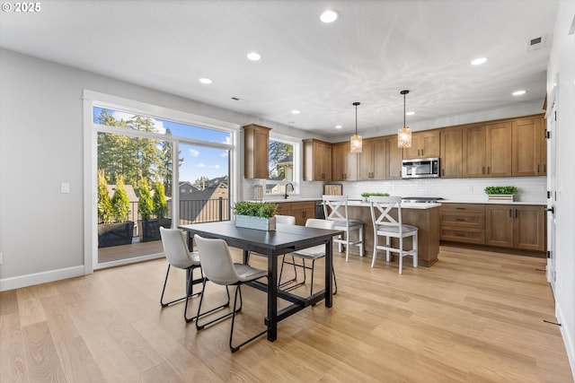 dining space featuring sink and light hardwood / wood-style flooring